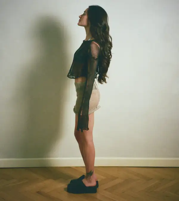 Profile: same look, arms down.