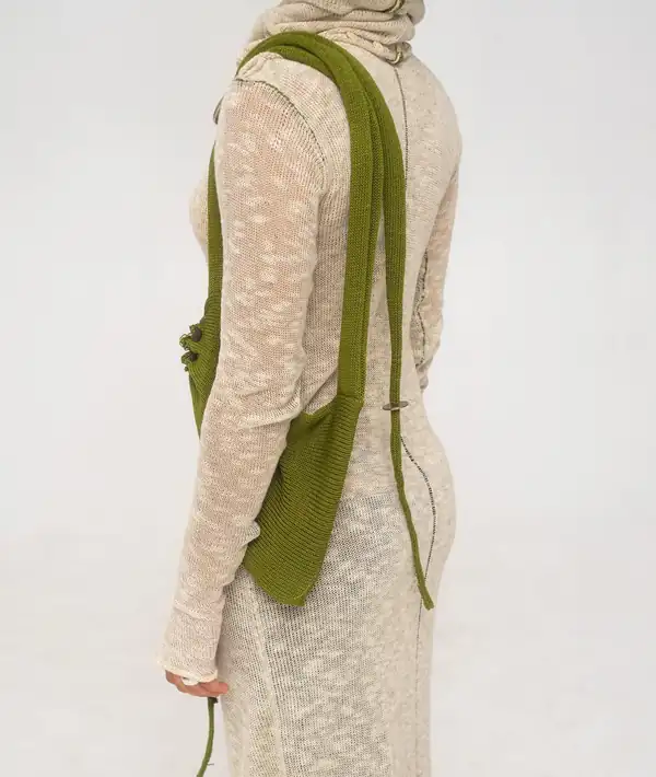 Back three-quarter: the cream dress and the olive bag on a long strap.