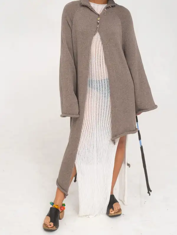 Front: the taupe coat partly buttoned over the white ribbed dress.