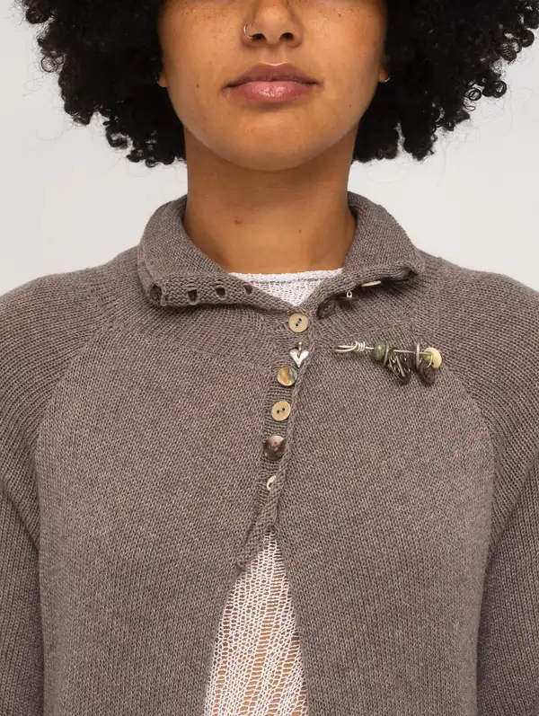 Close: the coat's collar, shell buttons and a small charm.