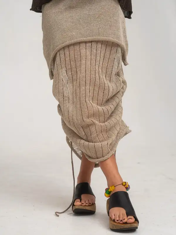Legs and feet: taupe ribbed knit skirt bunched, black platform sandals, beaded anklet.