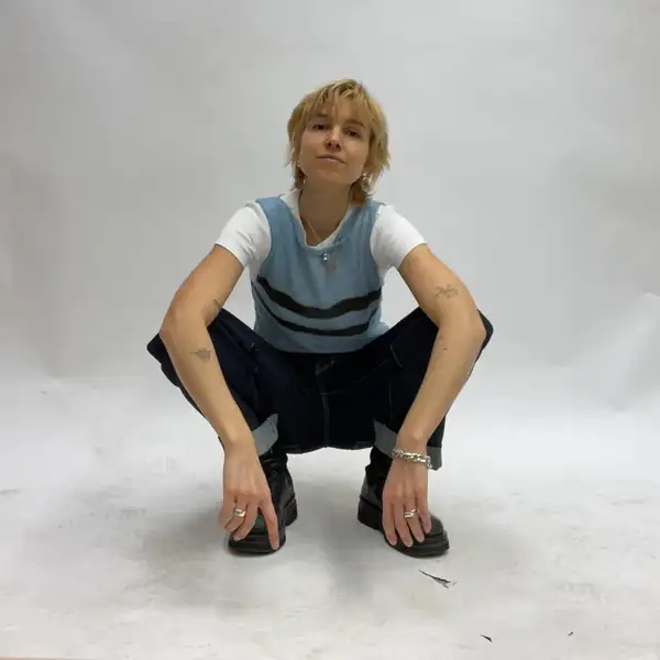 Crouching frontal: the striped blue knit tank over the white tee.