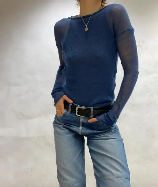 Standing, hands in pockets: the blue sheer knit long-sleeve with a contrasting sleeve.