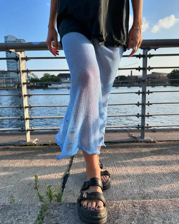 Hips down: the pale blue sheer knit long skirt with a rolled hem, black sandals.