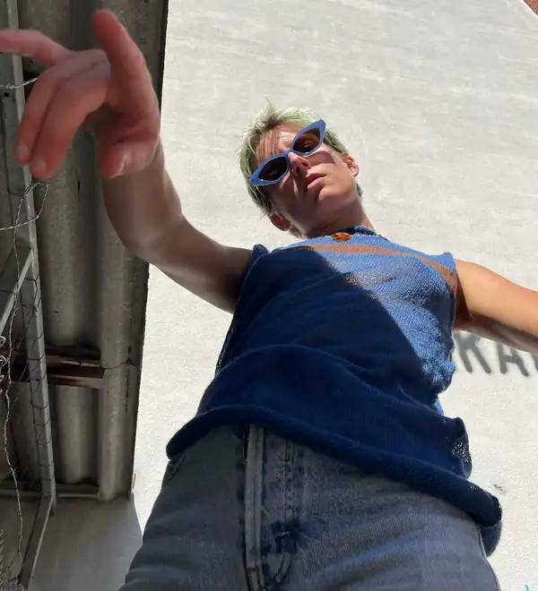 Low angle from below: the same top, an arm reaching to camera.
