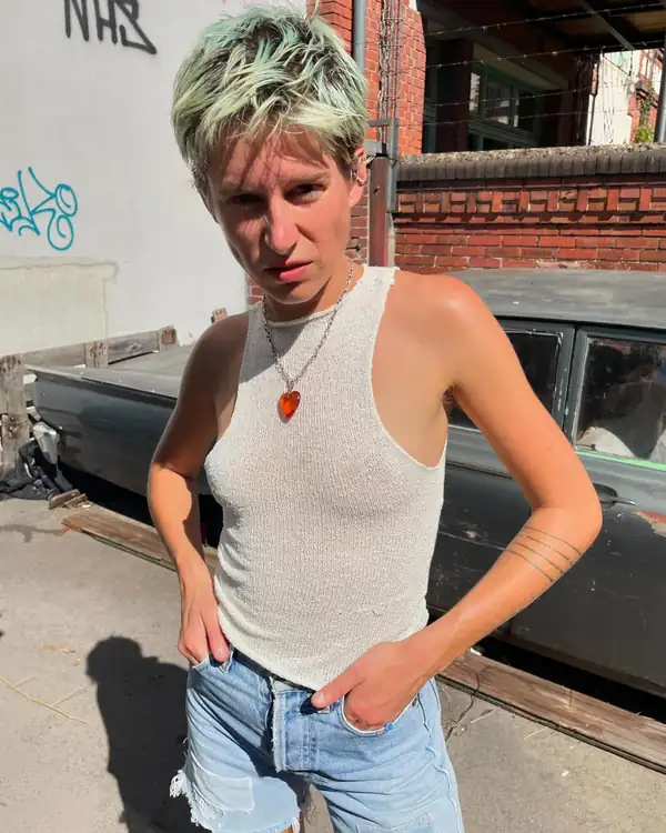 Portrait: the cream knit halter top, denim, graffitied wall.