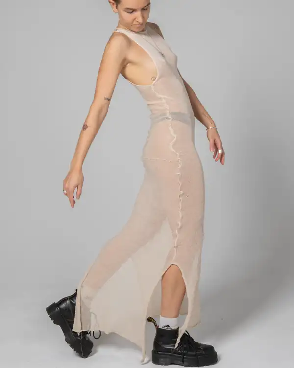Full-length walking: cream sheer knit long dress with a centre seam and front slit, black boots. Source of the site's Story image.