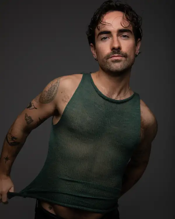 Close: the sage knit tank pulled at the hem, head and torso.