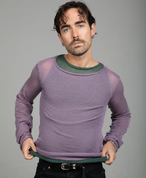 Front: lilac sheer knit long-sleeve with a sage-green neckline and hem, both hands pulling the hem. Source of the site's Longsleeve image.