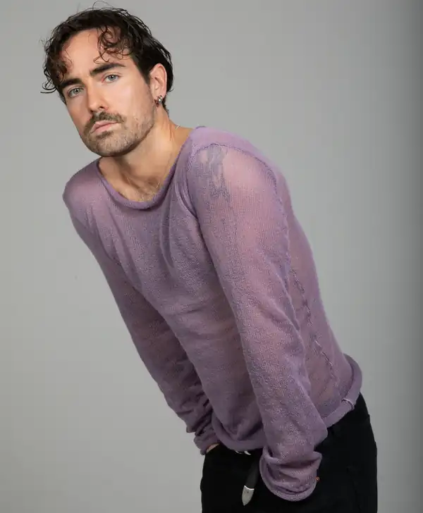 Leaning: the lilac knit long-sleeve, hands in pockets.