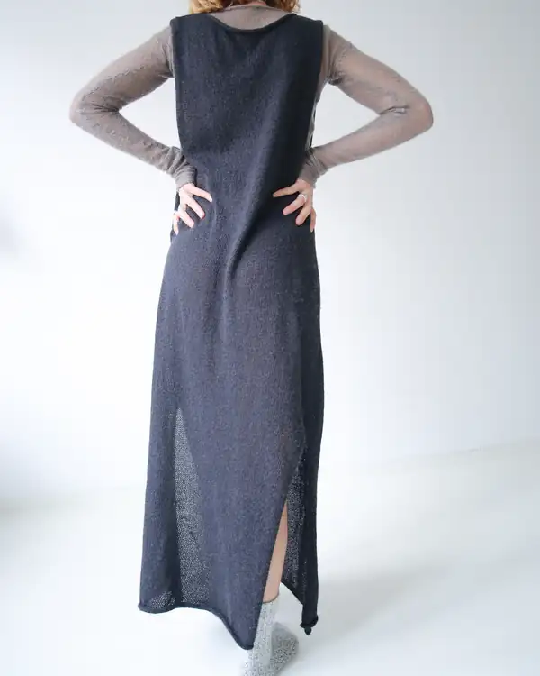 Full-length: charcoal knit sleeveless long dress with a front slit, over a taupe sheer long-sleeve.