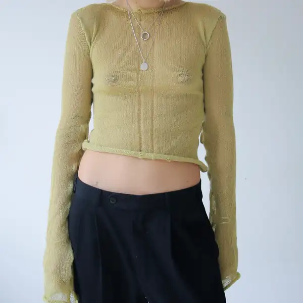 Chartreuse sheer knit long-sleeve with extremely long draping sleeves, black trousers, silver pendants.