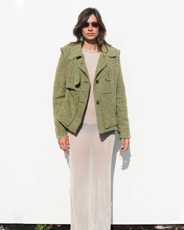 Front: the jacket open over the cream sheer dress, sunglasses.